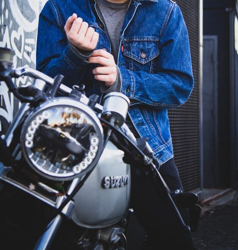 man riding on gray Suzuki motorcycle